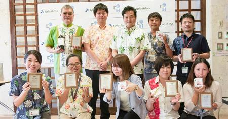 Splashtop team members smiling and holding awards, dressed in colorful attire with a Splashtop backdrop