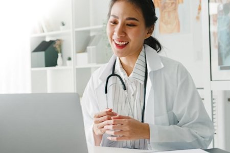 Smiling woman in healthcare industry using remote access software on a computer
