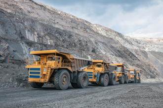 Line of yellow trucks operating at an iron ore mine site