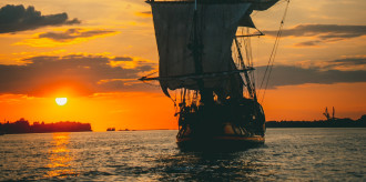 Old sailing ship on the sea into the sunset