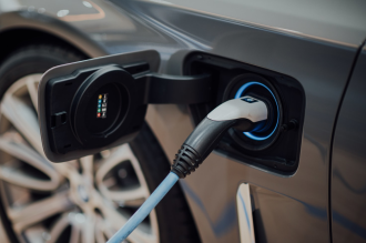 Electric car with lithium batteries plugged into charging station