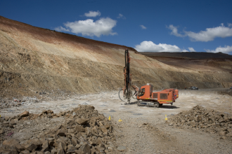 Drilling - heavy machinery drill holes to place explosive in holes to blast the rock in open cut mine