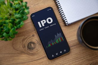 IPO 3 - golden phone with IPO stocks purchase app on the screen on wooden table