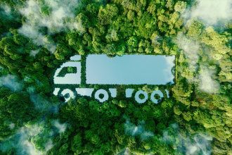 Green truck EV in a lush forest background