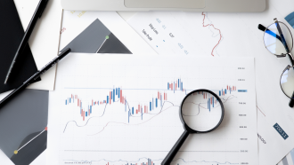 Magnifying glass over charts technical analysis