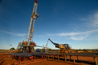 Perth, Western Australia, Aus Apr 1 2016 - A small onshore drilling rig uses a loader to move completion pipe or tubing to run into the well to produce gas for Perth area.