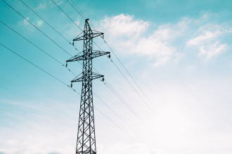 A transmission line sits before a blue sky