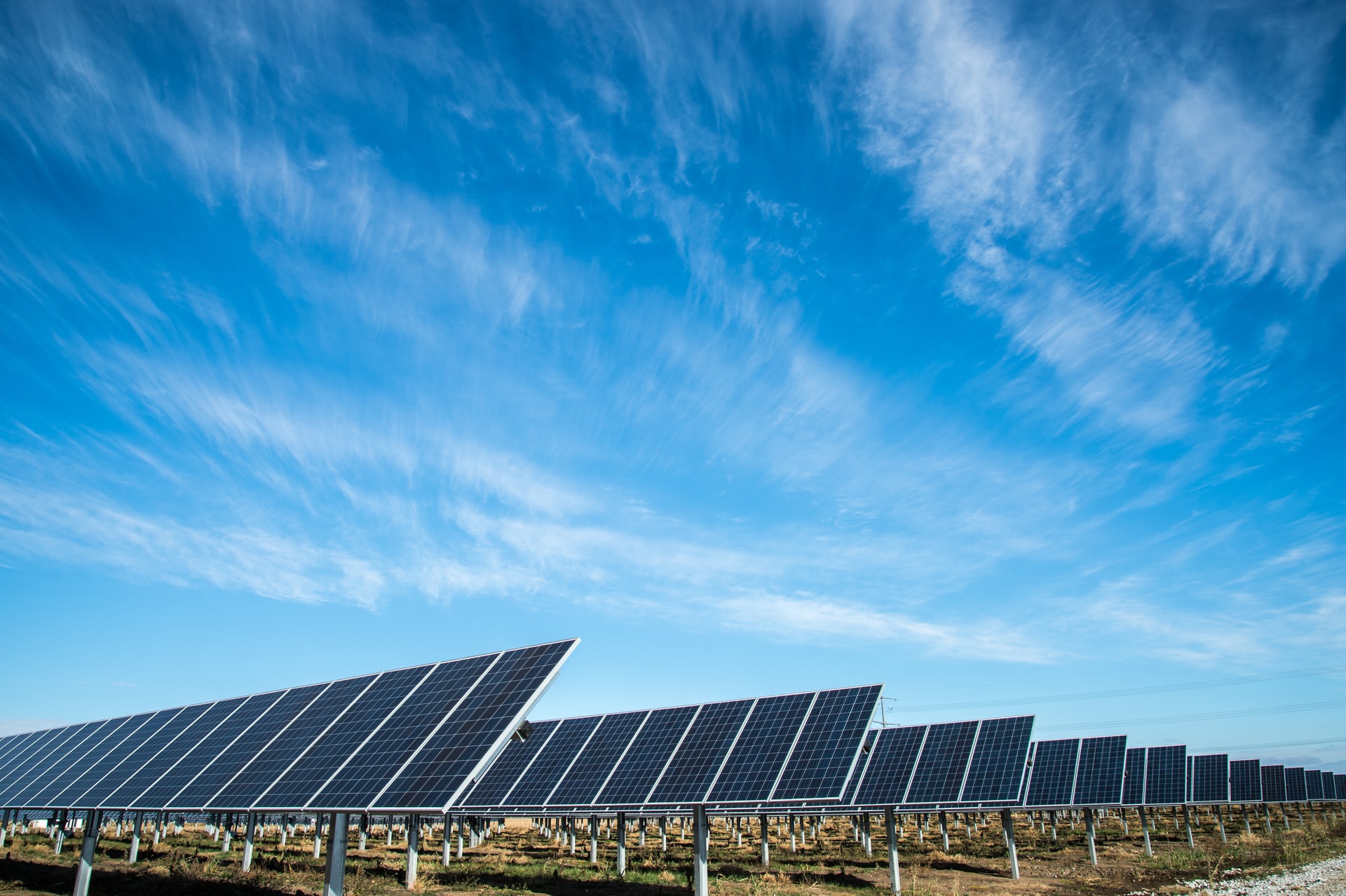 A grid-scale solar farm beneath a clear blue sky 