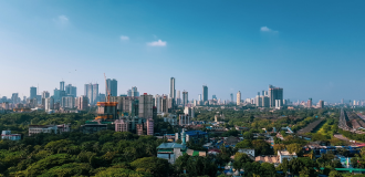 A snapshot of the city skyline of Mumbai, India, taken during the day under a blue, cloudless sky