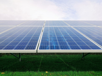 A PV solar panel faces the photographer underneath a blue sky 
