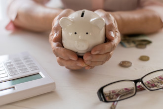 Super - Old women s hands put money in the piggy Bank, the concept of retirement, savings