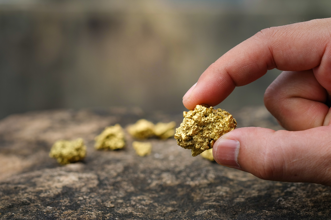 Field worker holds a gold nugget close to the camera for a better look