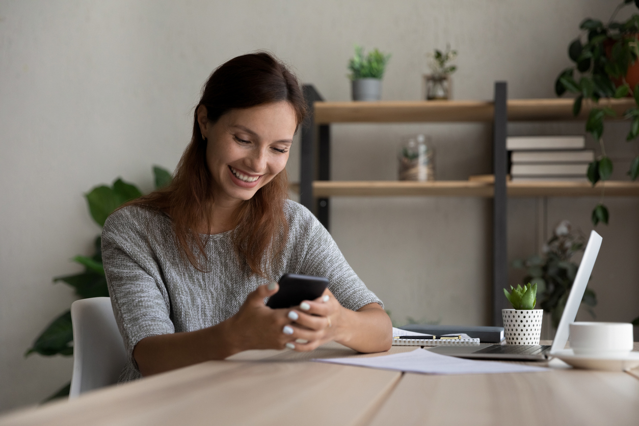 Reporting Season 8 - Happy young businesswoman texting on mobile phone