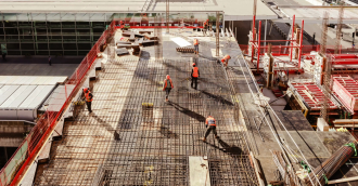 Construction - Construction workers at a construction site viewed from above, High angle view of five people with helmets.