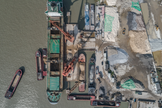 An unknown mining operation with a constructed export wharf alongside it is photographed from above in an unknown location