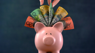 Super - Pink Piggy bank money concept on dark blue background, stuffed with Australian cas