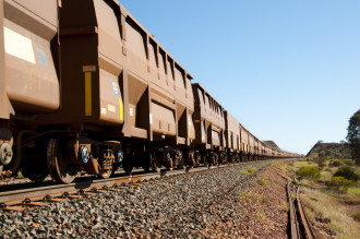 A train of ore carts extending into the horizon in an Australian setting