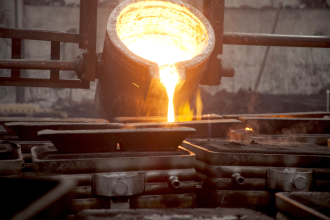 White-hot molten metal is poured into moulds at an unknown factory in an unknown location 