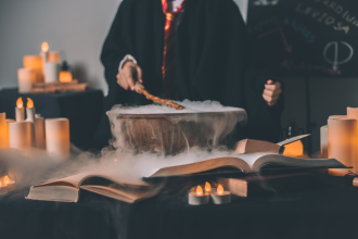 A wizard in the style popularised by the Harry Potter books stirs a cauldron with a magic wand