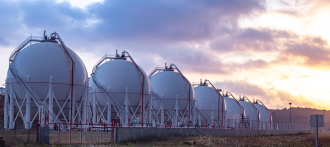 A row of gas storage tanks are photographed in an unknown location 