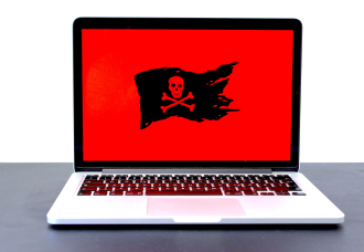 A laptop screen displays a pirate flag against an all-red background, reminiscient of screens victims of ransomware attacks may see when trying to use a compromised device