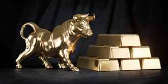 A golden statuette of a bull stands next to a stack of six gold bullion bars 
