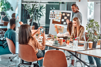 M A 8 - team of young professionals working at a large table using modern technology devices