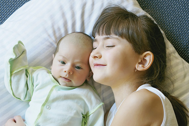 Hermana mayor ayudando a su hermano pequeño a prepararse para la