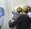 Madre e hijo mirando por la ventana de un avión