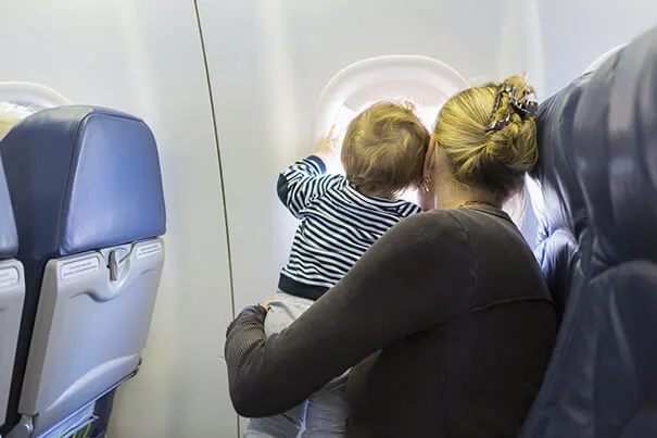 Madre e hijo mirando por la ventana de un avión