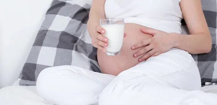 Mujer embarazada cuidando su alimentación consumiendo calcio