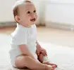 Bebé sentado en alfombra