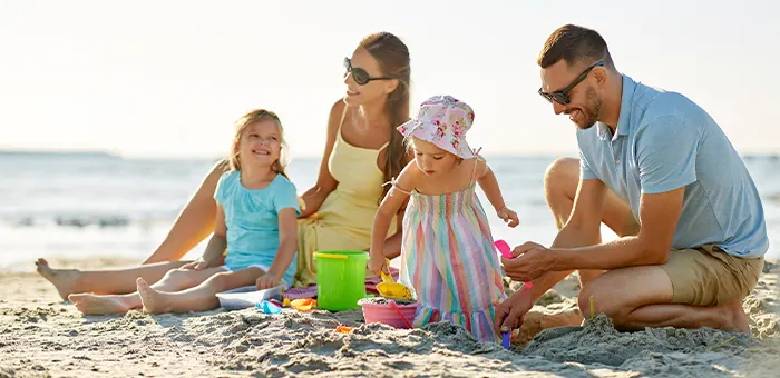 Familia jugando en la playa. Actividades para niños de 2 a 3 años