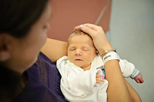 Madre alzando a su hijo recién nacido