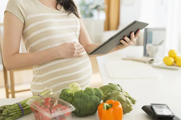 Mujer embarazada buscando recetas para cocinar