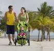 Pareja de padres con su hijo en coche caminando en la playa