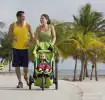 Pareja de padres con su hijo en coche caminando en la playa