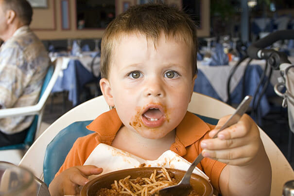 Bebé comiendo pasta con la boca sucia