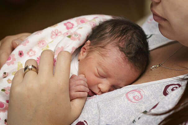 Mamá cuida de los bebés de las uñas. Close-up. Sierras irregularidades con  una lima de uñas a un niño recién nacido. La mamá y el cuidado del bebé.  Cuidado de las uñas