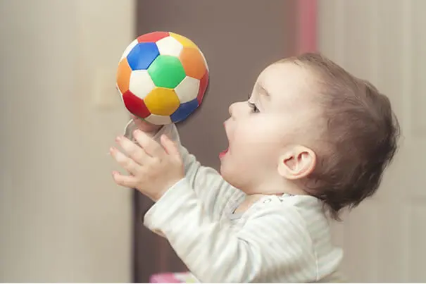 Bebé jugando con un balón de colores