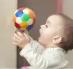 Bebé jugando con un balón de colores