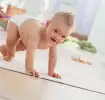 Bebé en pañales aprendiendo a caminar