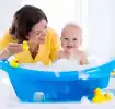 Mamá bañando a su pequeño en bañera de bebé.