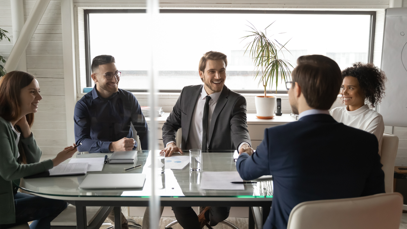 Smiling businessmen handshake closing deal at meeting