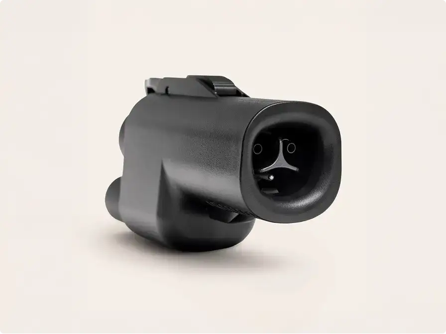 Black muzzle device or compensator for a firearm with a triangular logo inside the barrel opening against white background.
