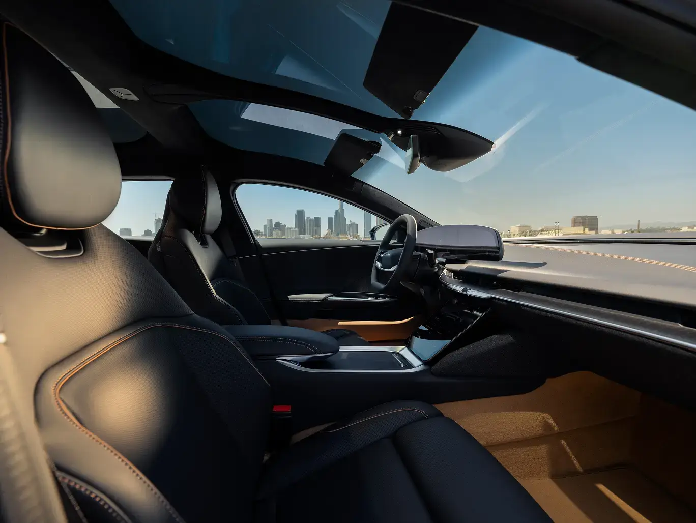 Sleek black car interior with leather seats, panoramic sunroof, and a city skyline visible through the windshield.