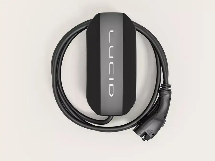Lucid-branded black and gray EV home charging unit with coiled black charging cable and connector on white background.