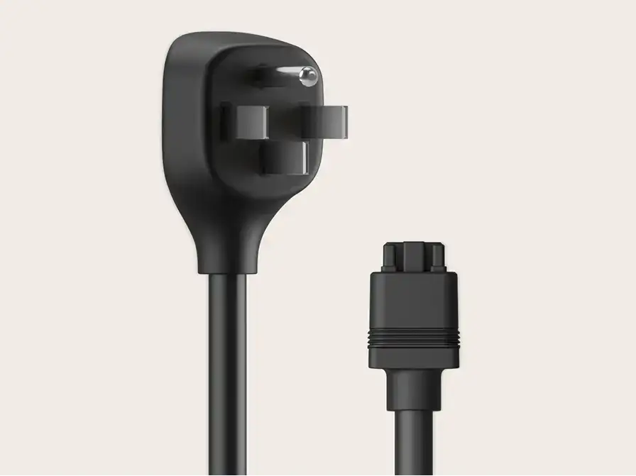 Black power cable with a flat angled wall plug on one end and a small connector on the other, on a light beige background.