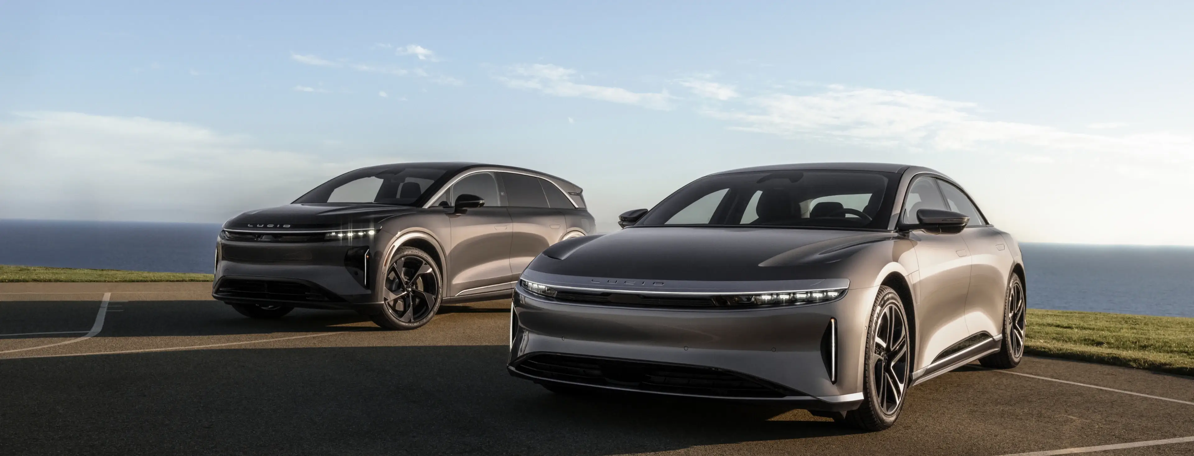 Lucid Air en Lucid Gravity die bij de kust geparkeerd staan, met de oceaan op de achtergrond.