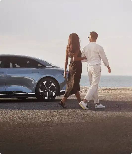 Couple walking beside a Lucid Air